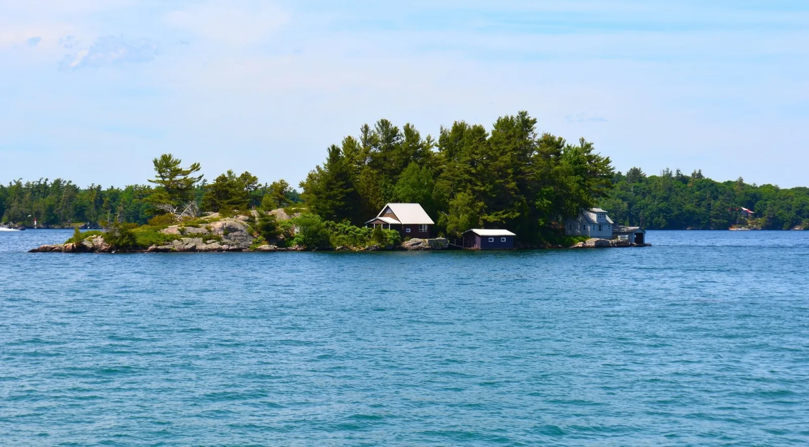 Small rocky island with a cottage and boathouse, typical of the Thousand Islands